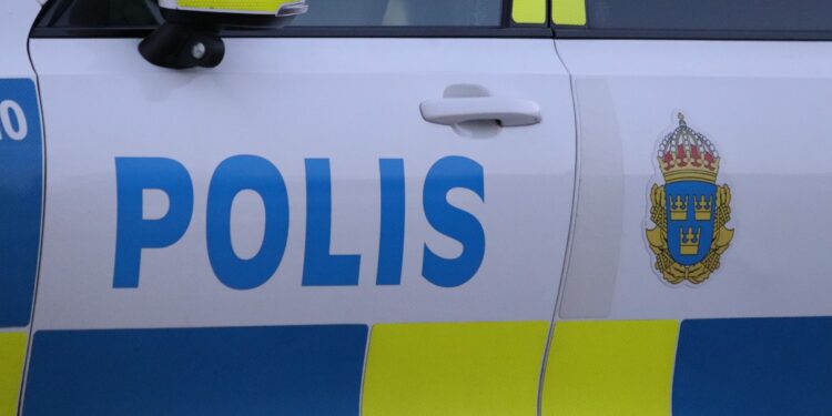 Polisbil där vänster framdörr är inzoomad med polisens logga.